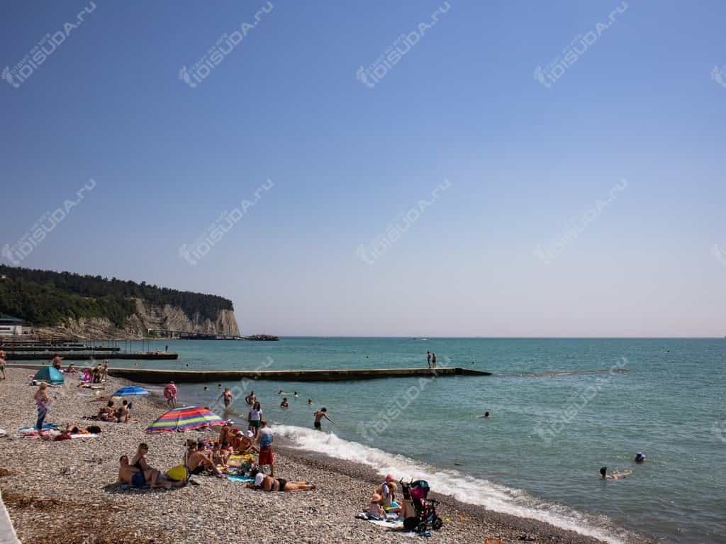 Вид на один из пляжей Дивноморского, утес, отдыхающие, лежаки и волнорез