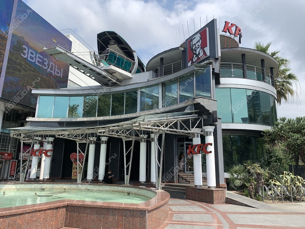 вид с улицы на ресторан KFC в Сочи, деревья, вывеска, окна, фонтан
