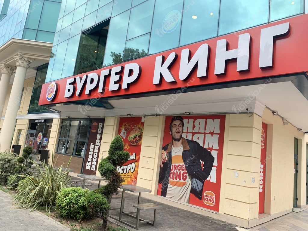 вид с улицы на ресторан Бургер Кинг в Сочи, вывеска, окна, малые архитектурные формы, столики на улице
